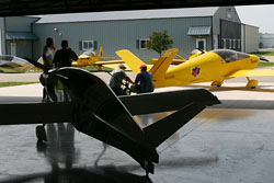 Fly-In attendees inspect the Y-tail of the Xenos Motorglider. Fly-In attendees were able to see the heritage of current Sonex Aircraft, as the Monex Racer, on loan from the EAA AirVenture Museum for refurbishment, was on display (foreground) along with the original prototype Sonerai I