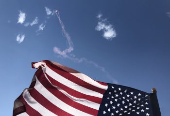 The Patriot Parachute Team kicks-off Monday's airshow carrying the American flag for the singing of the National Anthem.